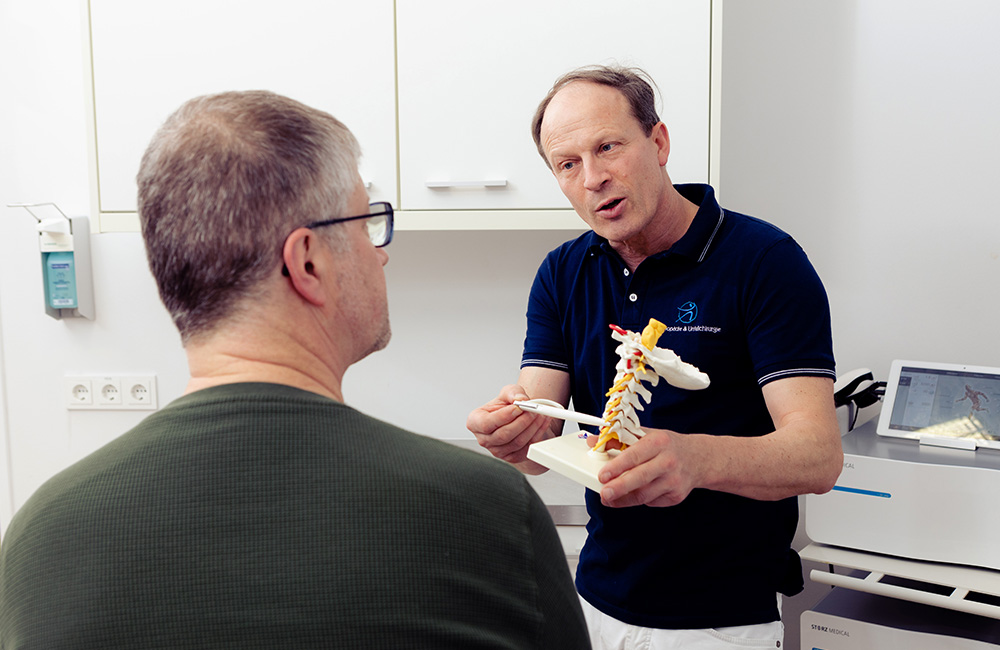 Behandlungsgespräch mit einem Patienten über die regenerative Sportmedizin.