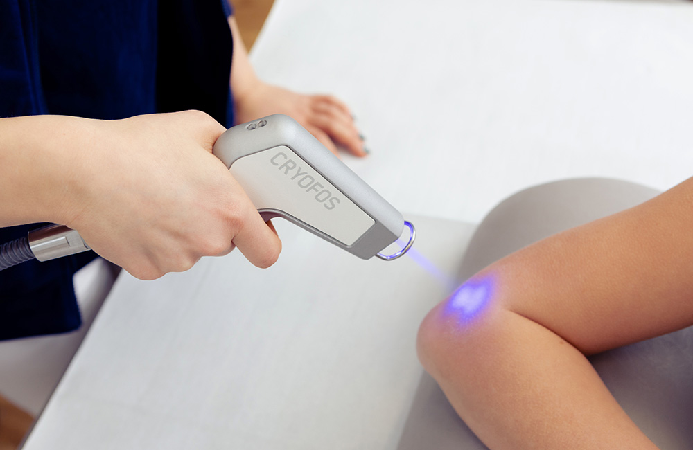 Kältereiztherapie am Ellenbogen durch eine Mitarbeiterin.