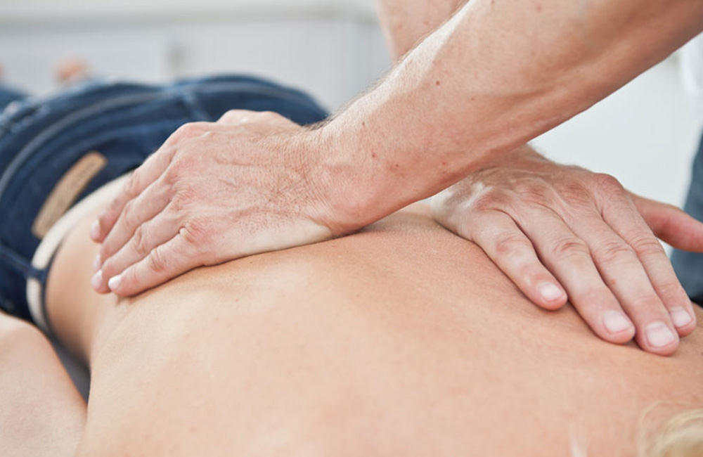 Manuelle Medizin - Osteopathie - Chiropraktik am Rücken eines Patienten.