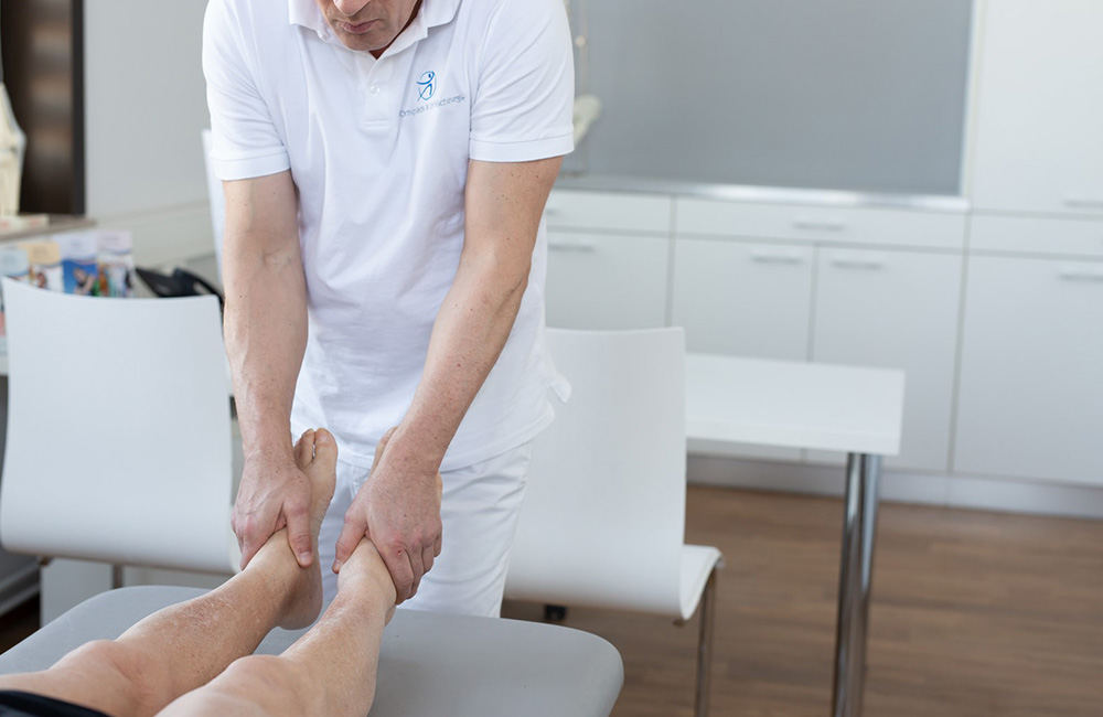 Moderne Diagnostik Ihren Schmerzen auf der S. Dr. Nalbach behandelt die Beine einer Patientin.