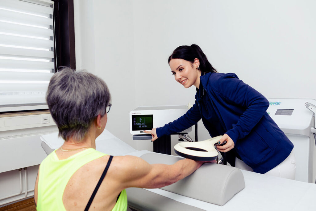 Magnettransduktionstherapie (EMTT) zur Beschleunigung der Regeneration. Eine Mitarbeiterin behandelt eine Patientin.
